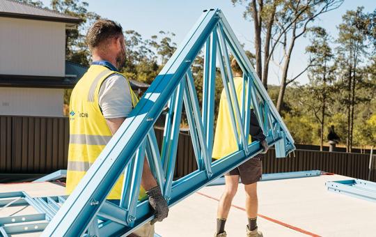 Tradies carrying TRUECORE steel trusses