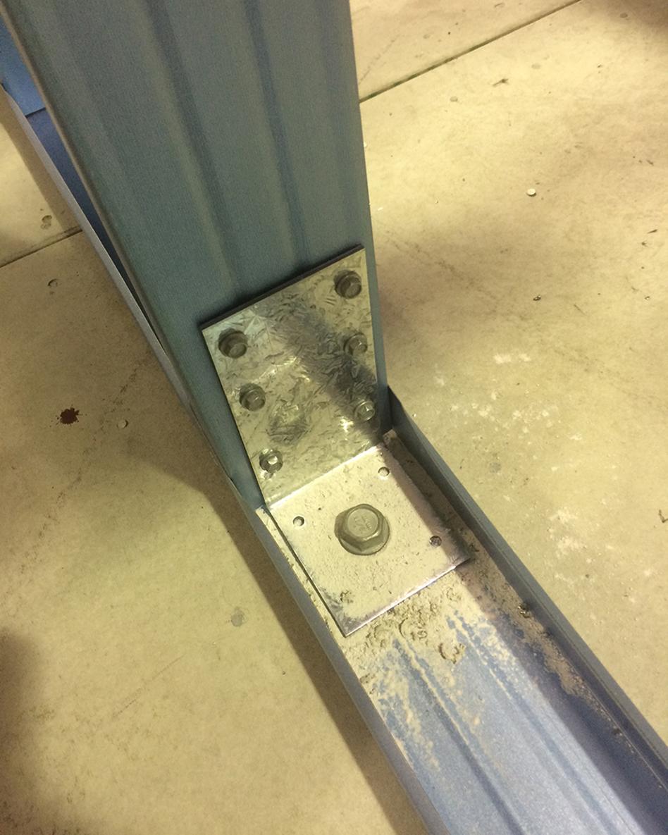 Masonry anchor attaches to both stud and bottom plate and studs act as a tie-down rod for truss connections